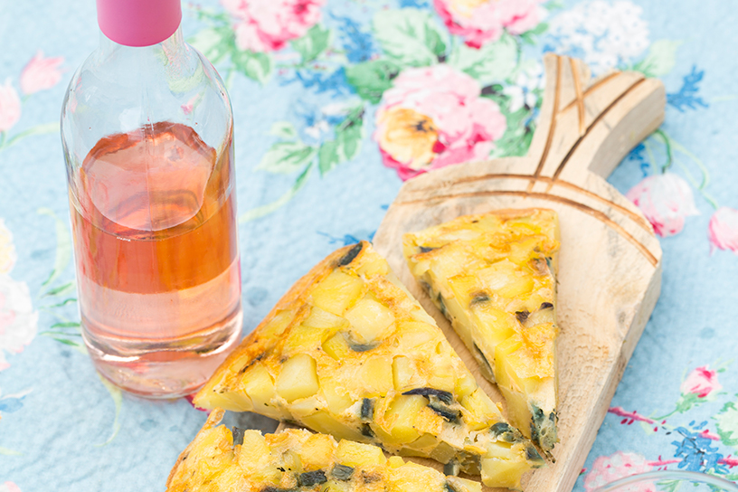 stukken eten op een houten plank met een glas drinken ernaast